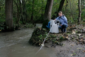 En kvinde overvåger vandkvaliteten for en flod i en skov