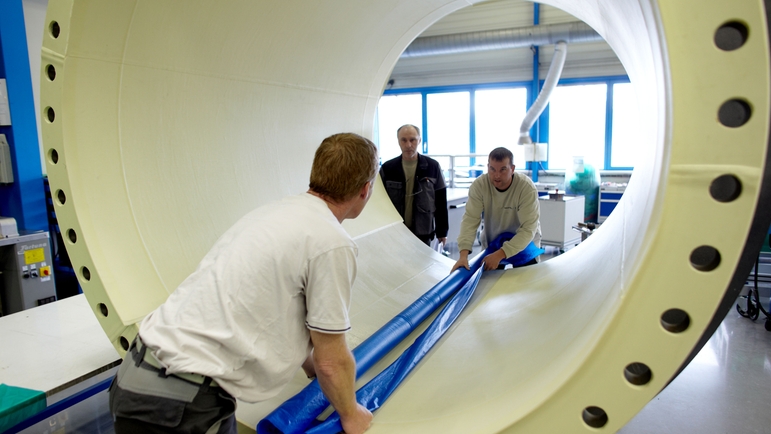 Endress+Hauser Flow, Frankrig, Cernay, mænd, der kigger igennem en flowmåler med stor diameter