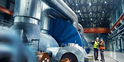 Nærbillede af en tekniker foran en turbine på et kraftværk
