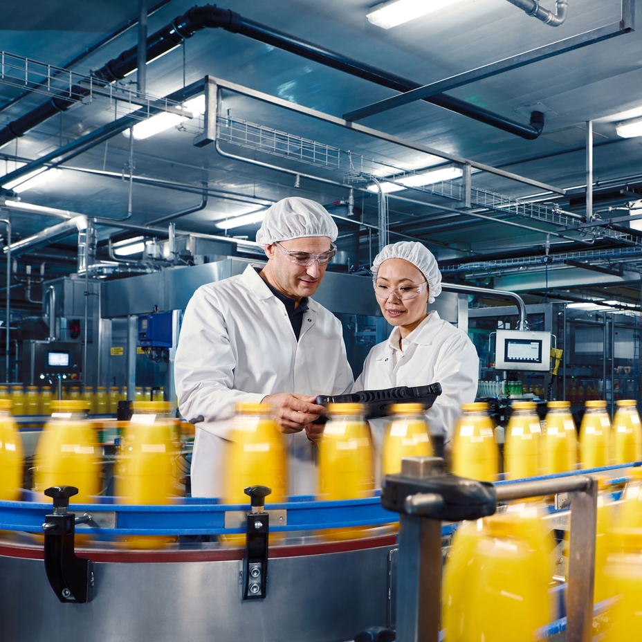 Medarbejder, der står foran en produktion af drikkevarer