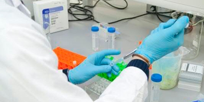 En laborant i føde- og drikkevareindustrien udtager manuelle procesprøver til analyse i anlæggets' laboratorium