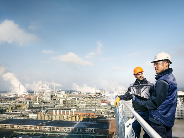 To teknikere ser på et stort industrielt anlæg.